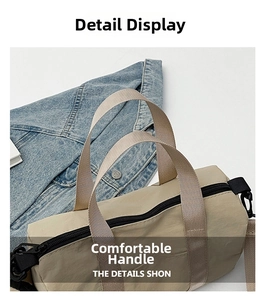 Detail view of beige nylon pillow bag featuring a dual zipper and durable woven handle