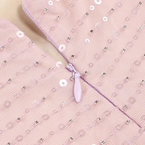 Détail de la fermeture éclair invisible et du tissu en maille pailletée sur la robe