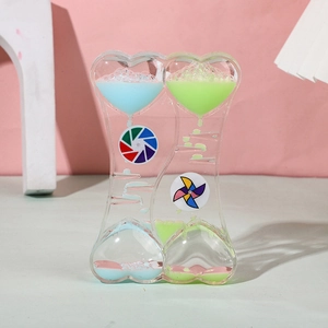Heart-shaped liquid hourglass sensory toy with blue and pink drops and windmills