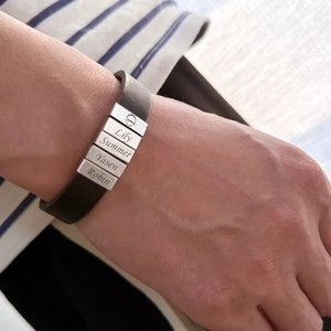 Gros plan d'un bracelet en cuir pour homme avec cinq perles métalliques gravées au choix