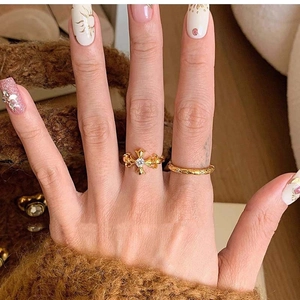 Detail of vintage gold fleur-de-lis ring with crystal and matching textured band