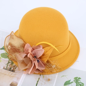 Elegant mustard yellow wool felt bowler hat with pink mesh flower and feather accents
