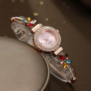 Detail of rose gold quartz watch featuring floral rhinestone chain and pink dial