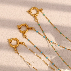 Detailed view of 18K gold plated necklaces with green, blue, and white beads and spring clasps