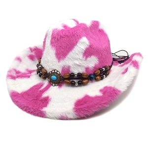 Détail d'un chapeau de cowboy rose à motif vache avec perles et turquoise décorative