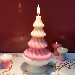 Dual-layer pink and white Christmas tree candle on a white ceramic pedestal stand