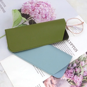 Detailed view of olive green and light blue PU leather eyeglass pouches with soft texture