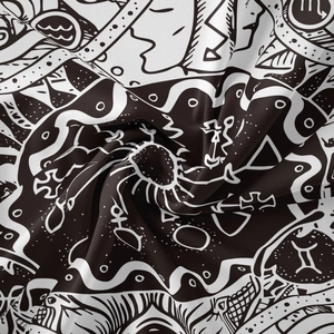 Close-up of bohemian tapestry showing intricate black and white mystical tree patterns