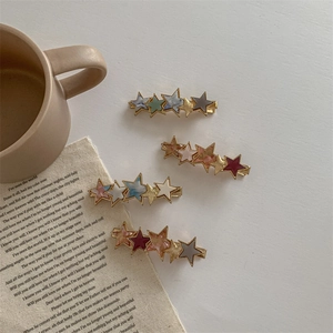 Star shaped acetate hair clips in colorful finishes on a minimalist retro background