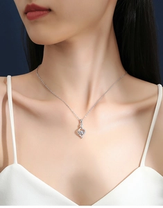 Close-up of S925 silver necklace with sparkling heart and infinity symbol pendant