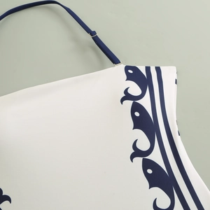 Detailed close-up of blue halter straps and printed swimwear fabric with wavy patterns