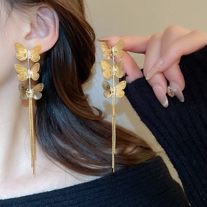 Close-up of gold butterfly tassel drop earrings with sparkling zircon stones detail