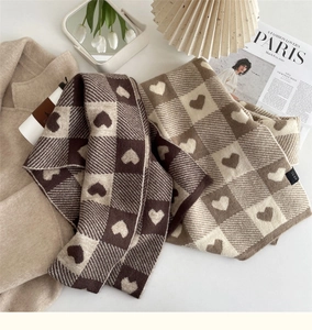 Detailed knit texture of heart checkered scarf in warm chocolate and beige colors