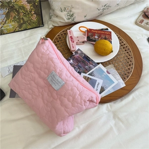 Pink quilted floral makeup bag with Beauty Studio label in a cozy aesthetic setting
