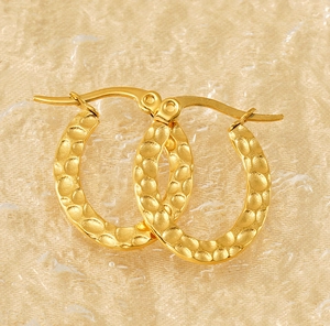 Detail of gold-plated stainless steel earrings featuring a textured hammered finish design