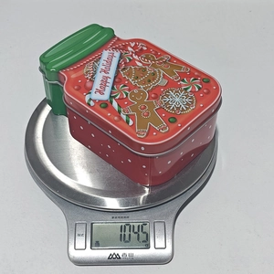 Close-up of Christmas tin jar showing festive gingerbread man lid design and 104.5g weight