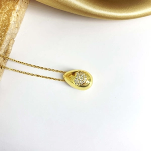 Détail macro du collier goutte plaqué or avec zircons sertis en forme de cœur