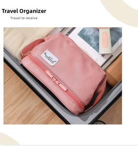 Detail view of the pink double-layer travel toiletry bag with zipper in a suitcase