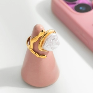 Bague élégante en acier inoxydable doré avec perle en forme de cœur sur un socle rose