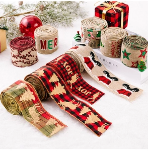 Detail of Christmas burlap ribbons with reindeer and festive patterns on plush background