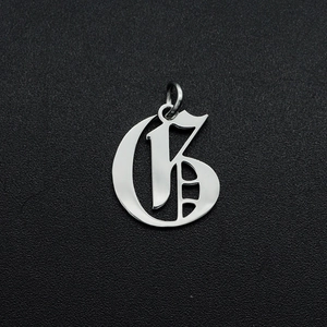 Detailed macro view of silver Gothic letter G pendant with stainless steel finish