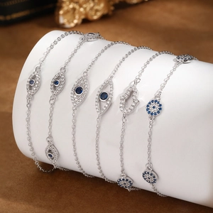 Macro shot of silver Evil Eye bracelets with blue zircon on a white display stand