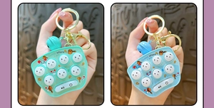 Detail of handheld game console keychain with bell charm in light green and blue