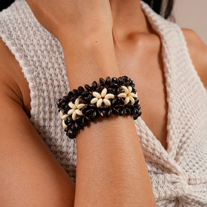 Detail of hand-woven coconut shell beaded bracelet with bohemian patterns on a wrist