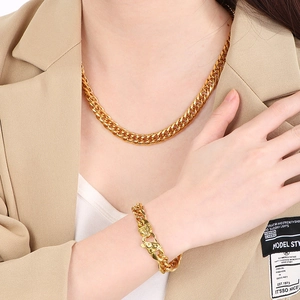 Set collana e bracciale a catena cubana dorata con chiusura testurizzata indossati