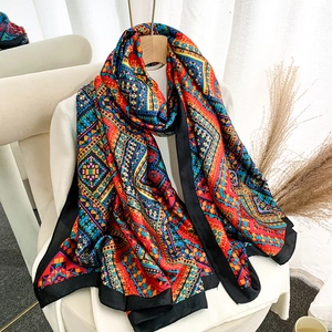 Long vintage silk scarf with colorful geometric patterns and black borders as a shawl