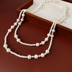 Macro detail of elegant double-layer white pearl necklace in a vintage brown gift box