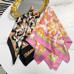 Silk square scarf with elegant floral prints displayed on a marble table for women