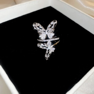 Close-up of elegant silver butterfly ring with shimmering zircon crystals on black velvet