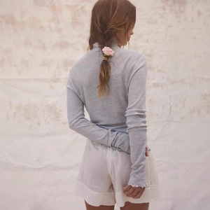 Back view of slim fit grey waffle knit long sleeve top with ruffle trim for women