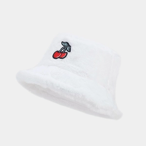 Detail of white plush bucket hat featuring red cherry embroidery and soft faux fur texture