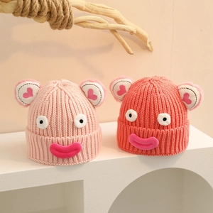 Détail de la maille du bonnet en tricot pour enfants avec de grands yeux rigolos