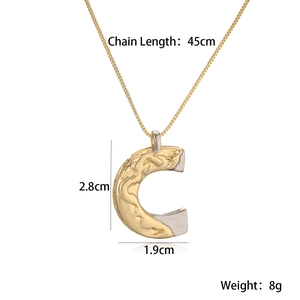 Detail of gold and silver tone letter C pendant necklace with dimensions 2.8cm by 1.9cm