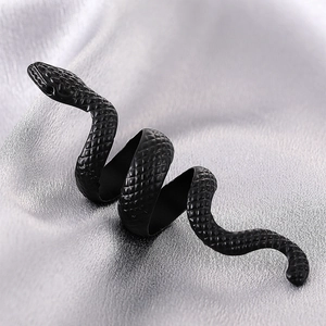 Detail of matte black snake ring with scale texture on silver silk fabric background