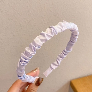 Detailed view of a light purple pleated satin headband with elegant fabric texture