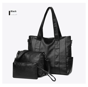 Three-piece black leather tote bag set including crossbody and clutch with gunmetal hardware