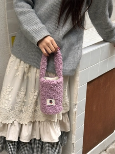 Close-up of soft purple plush cup holder bag with cute cartoon patch detail