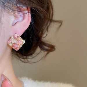 Detail view of square geometric earrings with pink enamel and sparkling zircon accents