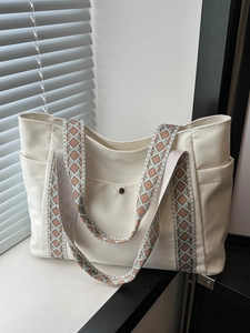 Grande borsa tote minimalista bianco sporco con tracolla geometrica colorata in luce naturale
