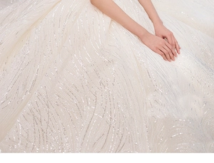 Macro view of heavy sequin embroidery and vine patterns on the luxury bridal gown