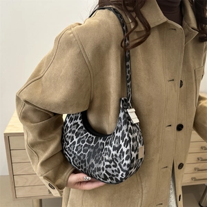 Retro leopard print crescent underarm bag with silver buckle worn by a model in a street shot