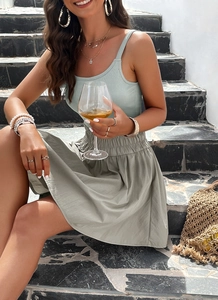 Detail of mint green ribbed camisole and sage green mini skirt on female model