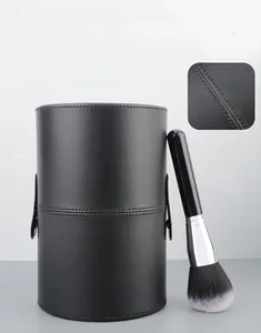Close-up of black PU leather makeup brush holder with dense stitching and soft powder brush