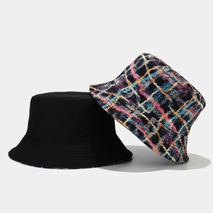 Close-up of double-sided bucket hat featuring black fabric and colorful plaid pattern