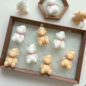 Detailed top view of mini bear candles in white and brown on a vintage wood tray