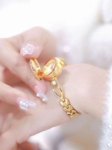 Macro detail of golden camellia bracelet watch with flip cover and crystal leaf accents
